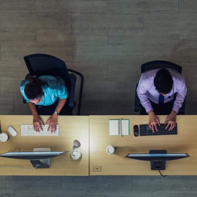 Bird's eye view of two people working on their computers